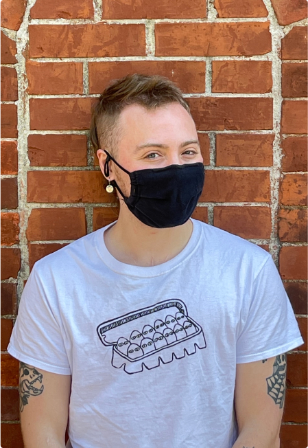Matt Trower in front of a brick wall with a FFP2 mask on his face